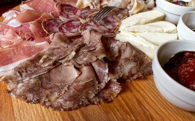 Rustic Emilian tray with typical products: prosciutto (ham), salami, coppa di testa, sliced cheese. Rocca Pitigliana, Bologna, Italy 