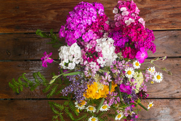 Bouquet of field flowers on brown wooden table