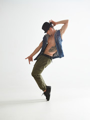 Fototapeta na wymiar Stylish young guy breakdancer in hat dancing moonwalk in studio isolated on white background. Dance school poster