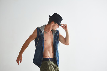 Cool young guy dancer in hat dancing hip-hop in studio isolated on white background. Break dance lessons