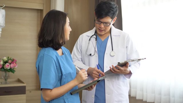 asian young doctor man talking with  nurse woman using digital tablet in hospital.