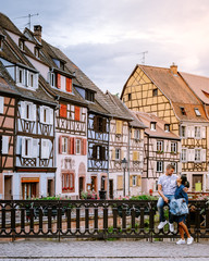 couple on city trip Colmar, Alsace, France. Petite Venice, water canal and traditional half...
