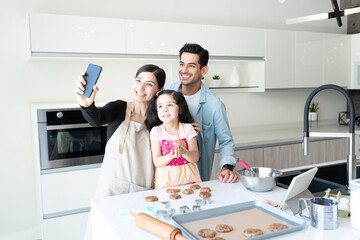 Cute Girl With Parents Taking Selfie In Kitchen
