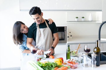 Obraz na płótnie Canvas Smiling Hispanic Couple Preparing Food At Home