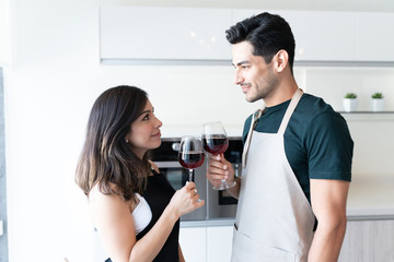 Affectionate Couple Holding Wineglasses At Home