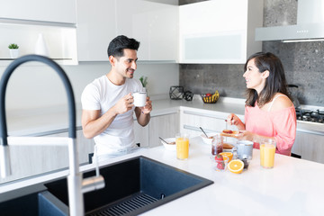 Couple Having Breakfast In Kitchen At Home