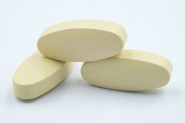 Vitamin tablets, Yellow tablets vitamin C medicine from bottle on white background.