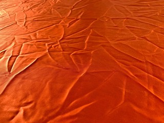 Orange cloth background full of creases