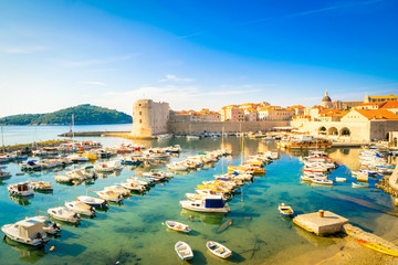 Fototapeta na wymiar East side of dubrovnik city walls with pier and many small ships docked in the morning.