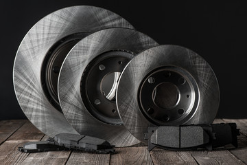 Set of various brake discs and friction pads on wooden table