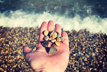 little  stones in hand on the sea shore