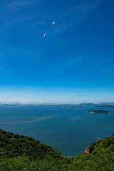 パラグライダーと瀬戸内海と空の青い風景が瀬戸大橋も背景に美しい
