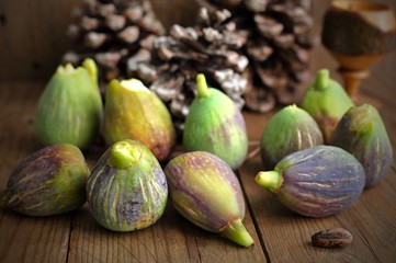 Fichi maturi appena raccolti e disposti su tavole di legno grezzo.