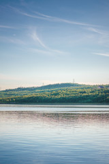 landscape with green forest background and reflections in water