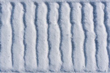 Abstract texture with a footprint of a snowmobile on the snow