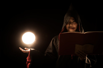 sorceress in black coat cast a spell calling lighting ball from hand on black background