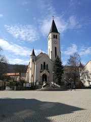 Fototapeta premium A church with a clock tower in front of a building in Tokaj