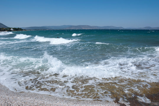 Athens, Greece, August 2020: Beautiful pebbled beach and stormy sea waters
