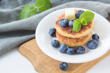 A healthy breakfast of pancakes, berries, butter, and honey