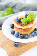 A healthy breakfast of pancakes, berries, butter, and honey