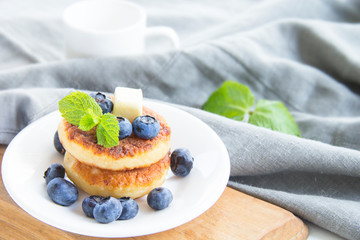 A healthy breakfast of pancakes, berries, butter, and honey