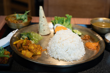 Indian metal plate with rice, chicken and pita bread