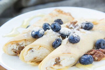 A healthy breakfast of pancakes, berries, butter, and honey