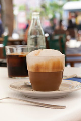 Cappuccino on table in Mediterranean cafe with blurred background