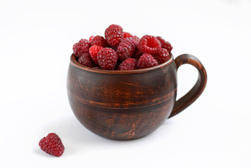 Ceramic mug with ripe juicy raspberries on a white background.