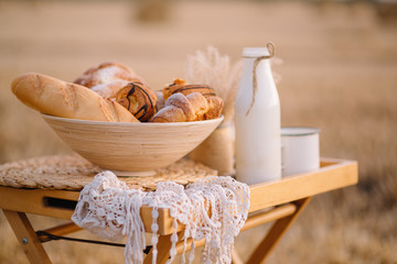 Composition from an assortment of fresh bread on a background of a mowed field of wheat.