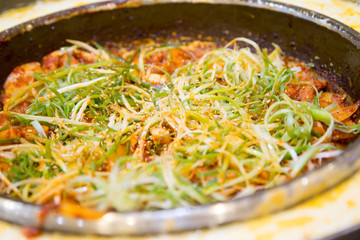 韓国料理のチーズタッカルビを食べる女性