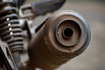 Close-up of a dirty bike silencer front view.
