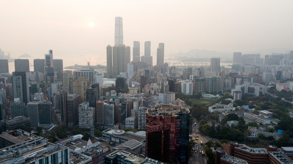 Hong Kong / March 28 2018: Aerial view of Hong Kong cityscape. Skyscrapers high glass buildings business centers roads car traffic daily city life. Concrete jungle. Megalopolis. Smog gray cloudy sky