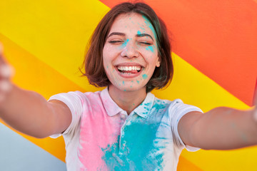 Excited woman taking selfie during paint party