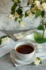 a Cup of tea and Jasmine flowers on the table on a spring morning