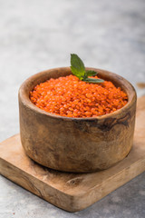 Red Lentil whole grain in a wooden bowl