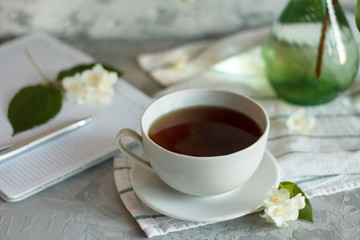 a Cup of tea and Jasmine flowers on the table on a spring morning