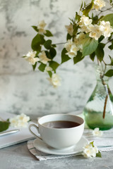 a Cup of tea and Jasmine flowers on the table on a spring morning