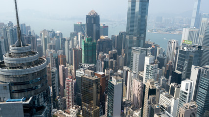 Hong Kong / March 28 2018: Aerial view of Hong Kong city. Skyscrapers, office glass buildings business centers near Victoria harbour bay concrete jungle megalopolis cityscape city life. Sunny blue sky