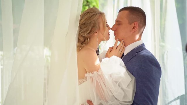newlyweds in rotunda with white curtains developing in wind