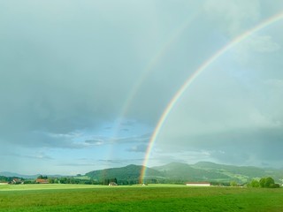 rainbow over green fields