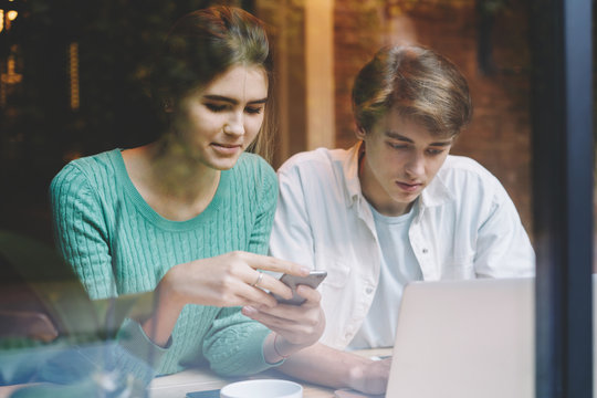 Antisocial Male And Female Teenagers Checking Email And Messaging In Chat Via Cellular And Computer Connecting To Wireless Internet Sitting Indoors And Ignoring Real Live Communication With Each Other