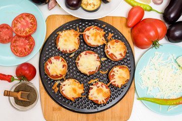 step-by-step recipe for homemade vegan pizza with eggplant for a bite, tomatoes, peppers, mozzarella . hands of a woman preparing a pizza with a view from above . light background.