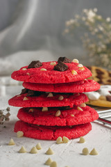  primer plano de galleta redvelvet  con chips de chocolate blanco y negro en una base blanca