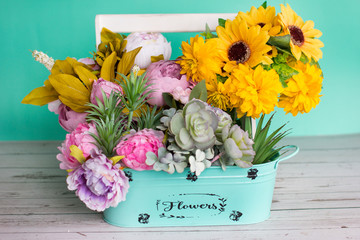 a bouquet of yellow flowers in a vase on a green pastel background. Design of flowers in the Studio.