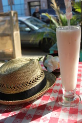 Straw hat and tall cocktail on red check tablecloth