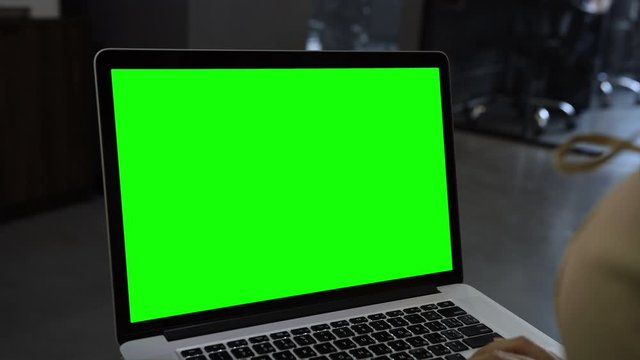 Laptop template with white transparent screen, computer blank display isolated. Metal device. Fingers press keys of the keyboard. Green