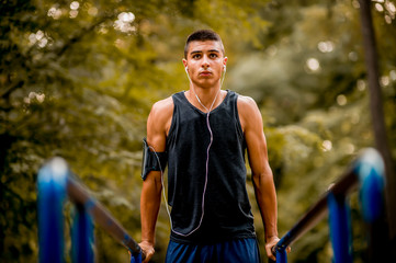 Sportsman with earphones training in the park