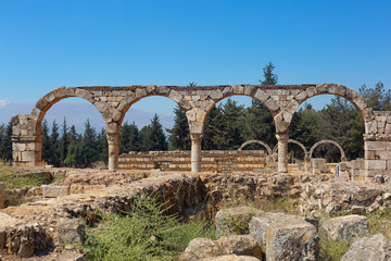 Fototapeta na wymiar Ancient ruins in the city of Anjar, Lebanon. Stone Colonnade and columns against a bright blue sky