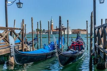 Fototapeta na wymiar Gondolas in summer in Venice with the church of San Giorgio Maggiore